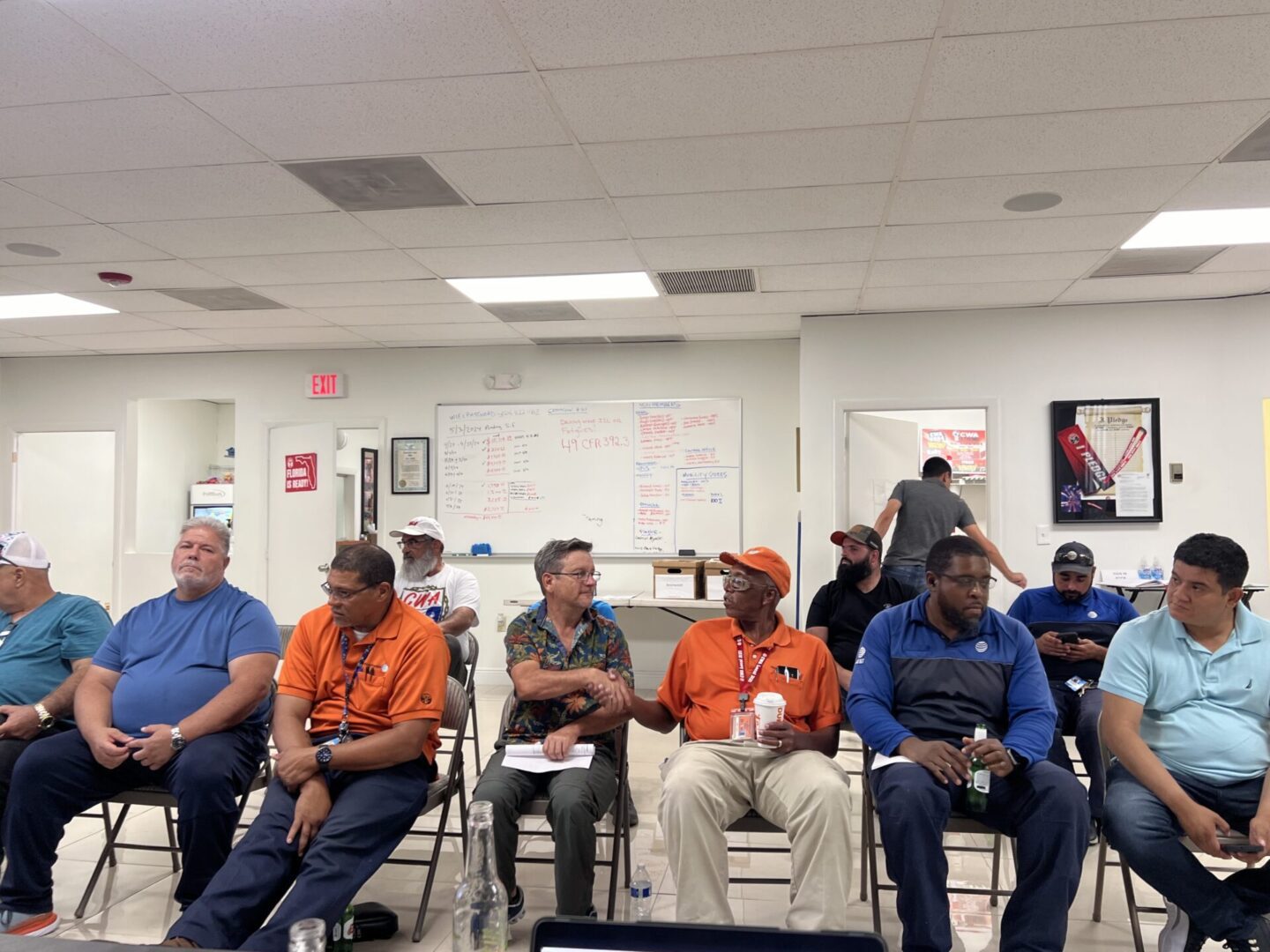 Group of men sitting in a meeting room.