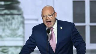 Man in suit speaking at a podium.